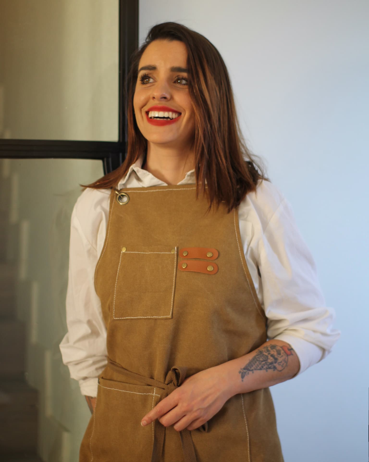 Rebeca, fundadora de Love and Bones, sonriendo con delantal artesano